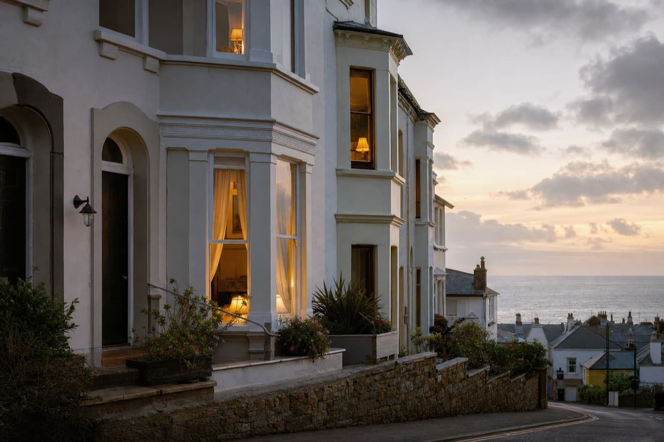 The seaside guest houses at dusk, lamps on in the windows