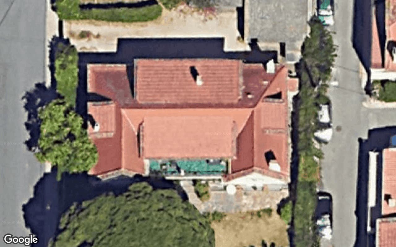 The house's red tiled roof from straight above, every slope visible