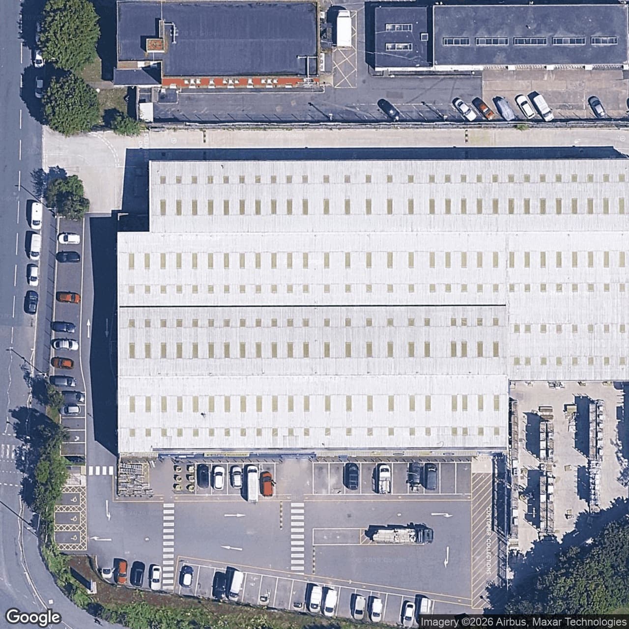 Before: the satellite tile of the Selco warehouse, its white roof bare