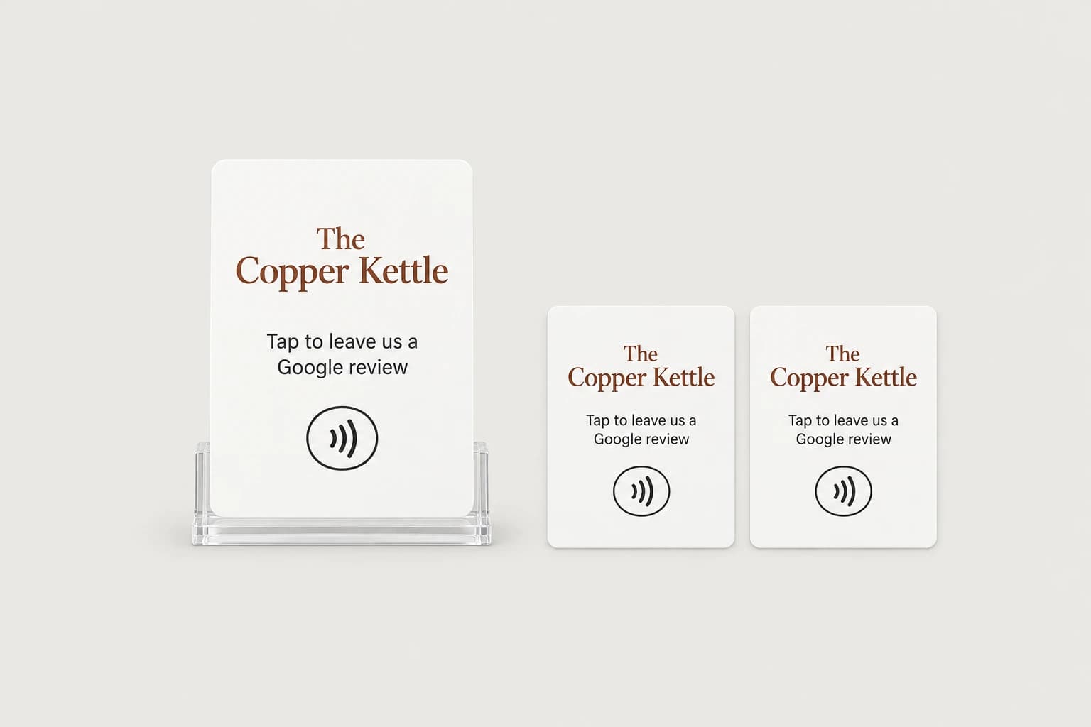 A clear acrylic counter stand holding The Copper Kettle tap card, next to two matching staff cards